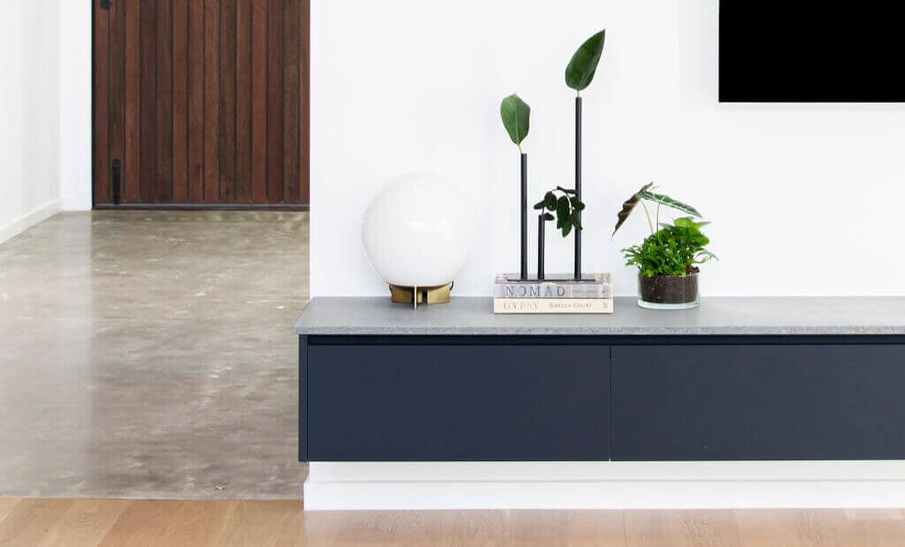 Interior styling featuring concrete floor, wooden door, indoor plants and Oak Lab Design minimal black vase